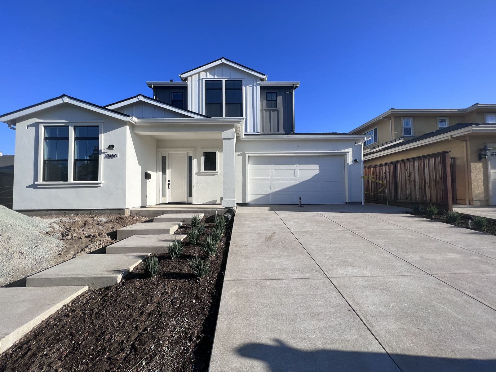 Newly built modern two-story home with a two-car garage and fresh landscaping
