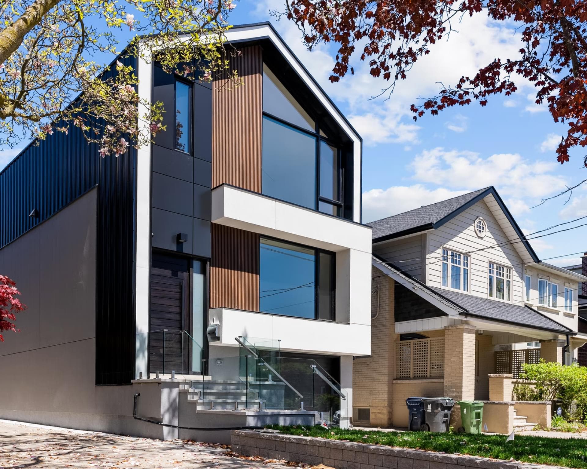 Modern remodeled home beside traditional houses on a tree-lined residential street